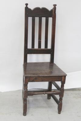 An 18th century vernacular oak high-backed hall chair with plank seat, height 113cm.