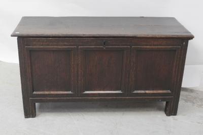 An 18th century oak three-panel chest with candle box and later paper lining, the top with wire-loop hinges, width 136cm.