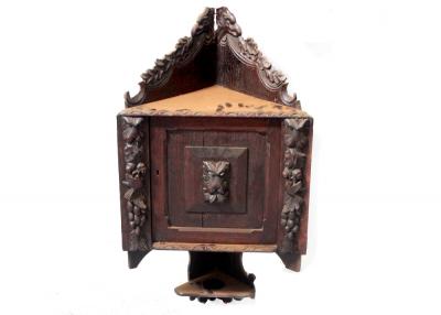 A 19th century oak carved wall hanging corner unit, carved top rail of oak leaves to single door with lion head carved panel, and carving to either side of lions, acorns and birds, approx 82cm.