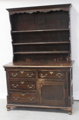 A 19th pine stained dresser of small proportions, curved top rail above three plate racks to three drawers to one side, one drawer over one cupboard door, to plinth and bracket support, 188 x 123cm.