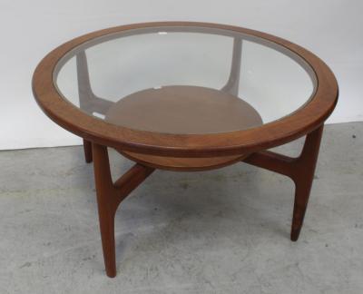 A circular G-Plan style teak coffee table with glass top surmounting four-legged frame base with circular shelf stretcher, diameter 81cm.