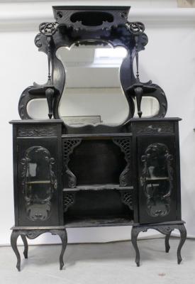 A late Victorian ebonised Empire cabinet, the shaped triple mirror surmounting a central bank of open shelves, flanked on either side by glazed cabinets, all supported on cabriole legs, height 195cm.