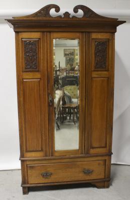 A late Victorian golden oak single wardrobe with mirrored door and lower drawer on bracket feet, height 205cm.