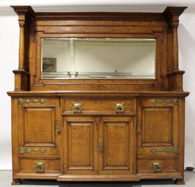 An early 20th century Arts & Crafts oak and pollard oak mirror-back sideboard with brass strap hinges, width 191cm.