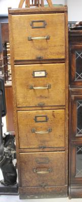 An early to mid 20th century oak four drawer filing cabinet with brass handles and information plates, 138 x 38cm.