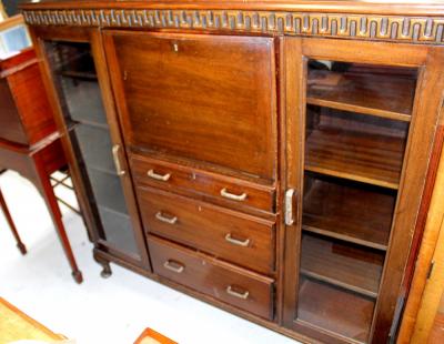 A 1930s mahogany bureau, the central fall with pigeonhole interior over three drawers flanked by a pair of glazed cupboard doors, height 122cm, width 122cm.