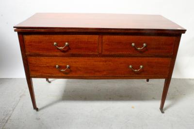 An Edwardian mahogany inlaid three-drawer chest, two short drawers over one long drawer, raised on tapering supports to brass caps and castors, previously a dressing chest, width 122cm, height 79cm.